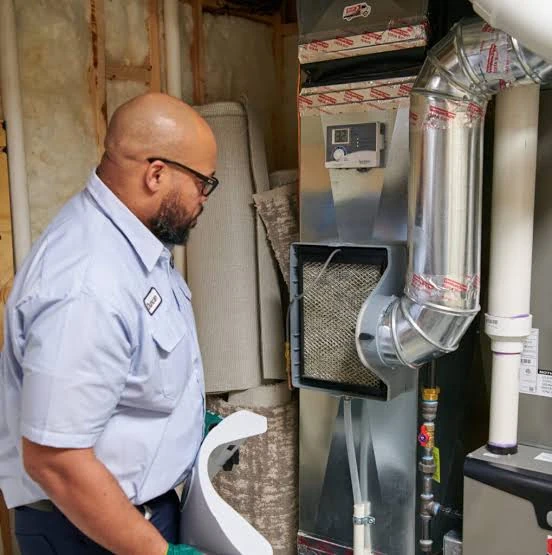 Technician inspecting an indoor furnace and its connected ductwork