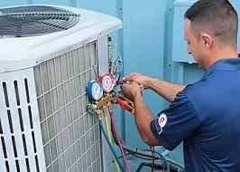 Technician reading pressure gauges connected to an outdoor air conditioning unit