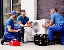 HVAC service team inspecting a compact outdoor unit with tools nearby
